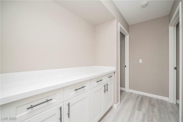 hallway with light wood-style floors and baseboards