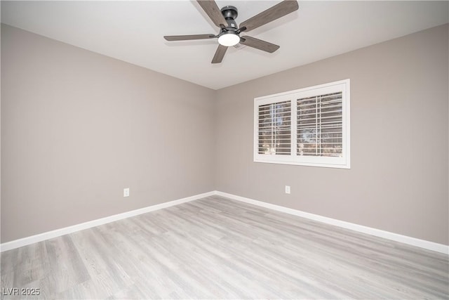 spare room featuring baseboards, light wood finished floors, and a ceiling fan