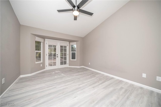 unfurnished room with french doors, light wood-style flooring, ceiling fan, baseboards, and lofted ceiling