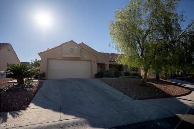 view of front of home with a garage, concrete driveway, stucco siding, and a tiled roof