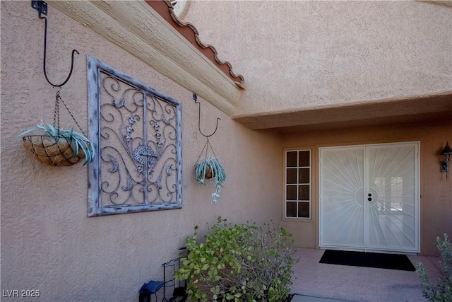 view of exterior entry with stucco siding