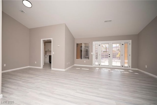 unfurnished living room with baseboards, lofted ceiling, light wood-type flooring, and french doors