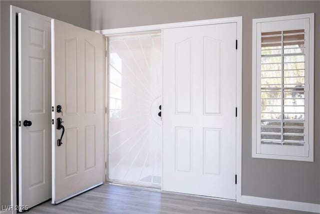 foyer entrance with wood finished floors and baseboards