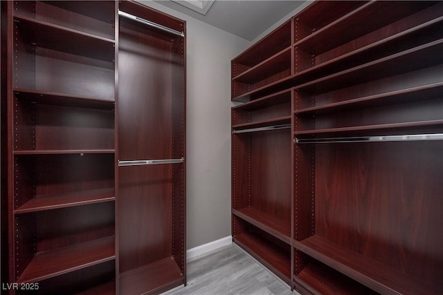 walk in closet with wood finished floors