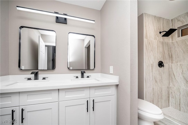 full bath with toilet, a tile shower, and double vanity