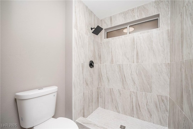 bathroom featuring toilet and tiled shower