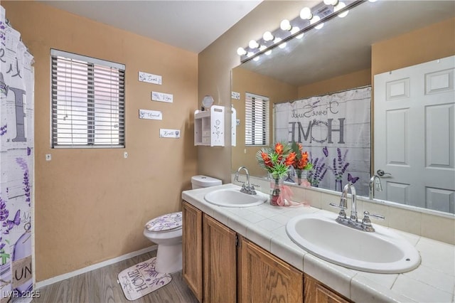 6408 Deadwood Rd, Las Vegas, NV 89108 - full bath with wood finished floors, toilet, double vanity, and baseboards