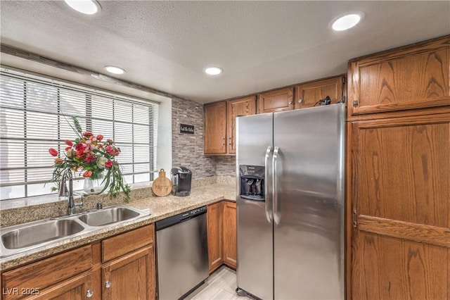 6408 Deadwood Rd, Las Vegas, NV 89108 - kitchen featuring appliances with stainless steel finishes, a sink, brown cabinets, light countertops, and recessed lighting