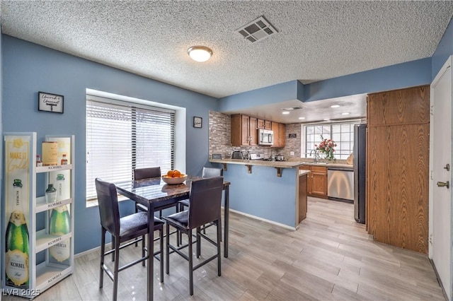 6408 Deadwood Rd, Las Vegas, NV 89108 - dining space with light wood-style floors and a textured ceiling