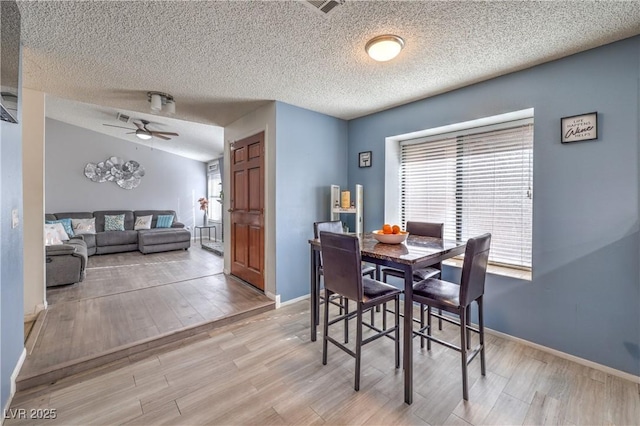 6408 Deadwood Rd, Las Vegas, NV 89108 - dining room with a textured ceiling, light wood-style flooring, ceiling fan, and baseboards