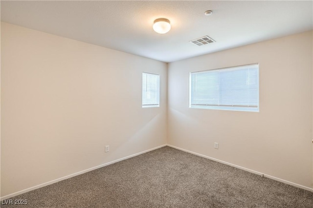 carpeted empty room featuring baseboards