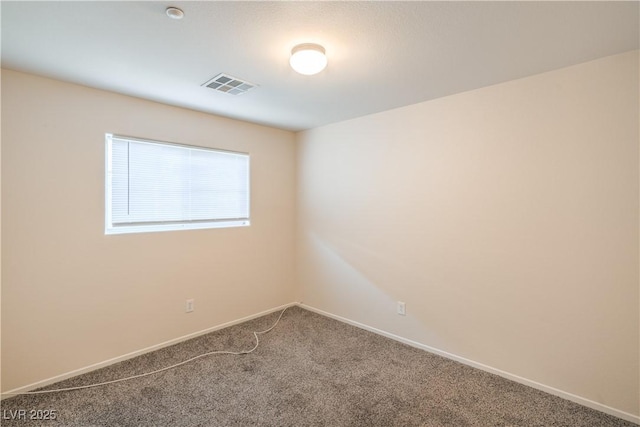 empty room featuring carpet and baseboards
