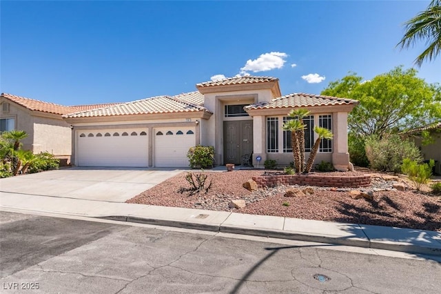 2587 Grizzly Park Ct, Henderson, NV 89052 - mediterranean / spanish house with a garage, stucco siding, driveway, and a tiled roof