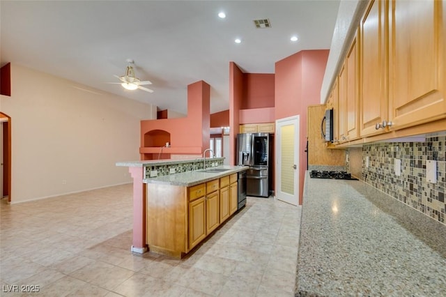 2587 Grizzly Park Ct, Henderson, NV 89052 - kitchen with black appliances, a sink, tasteful backsplash, light stone counters, and a ceiling fan