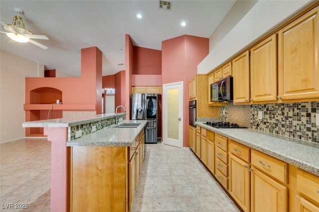 2587 Grizzly Park Ct, Henderson, NV 89052 - kitchen with a sink, black appliances, a ceiling fan, decorative backsplash, and light stone counters