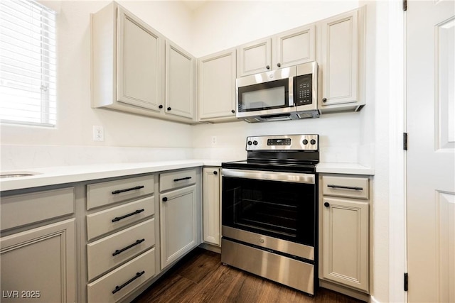 kitchen featuring appliances with stainless steel finishes, light countertops, dark wood-style floors, and gray cabinetry