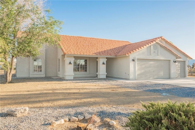 view of front of house featuring an attached garage, concrete driveway, stucco siding, and a tiled roof
