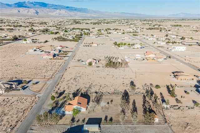 view of rural area with a desert landscape and a mountain backdrop