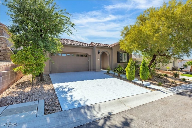 mediterranean / spanish-style house with an attached garage, decorative driveway, stucco siding, and a tile roof