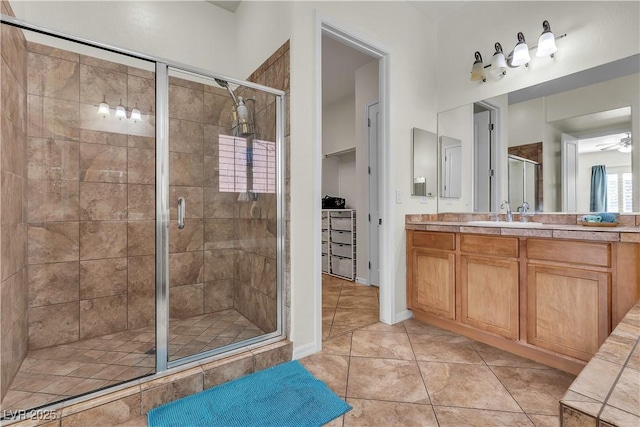 bathroom featuring a stall shower, vanity, tile patterned flooring, and ceiling fan