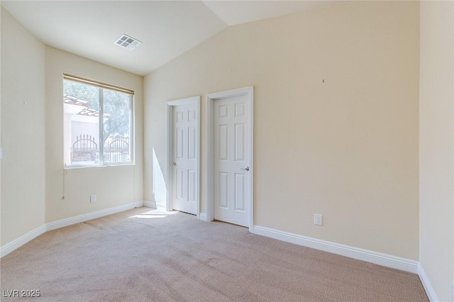 unfurnished bedroom with lofted ceiling, light colored carpet, and baseboards