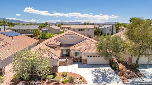 view of front of property with a residential view, a tile roof, a mountain view, and stucco siding