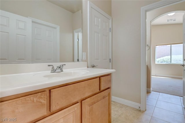 bathroom with tile patterned floors, vanity, and baseboards