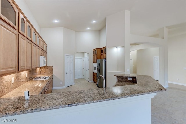 1963 Dakota Lodge Ave, Las Vegas, NV 89123 - kitchen with arched walkways, stainless steel appliances, light stone countertops, and recessed lighting