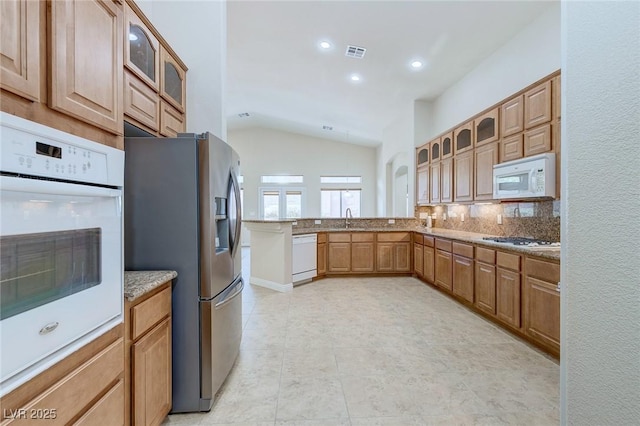 1963 Dakota Lodge Ave, Las Vegas, NV 89123 - kitchen with white appliances, a sink, vaulted ceiling, recessed lighting, and a peninsula