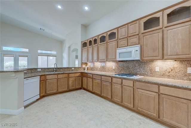 1963 Dakota Lodge Ave, Las Vegas, NV 89123 - kitchen with white appliances, a sink, light stone counters, backsplash, and a peninsula