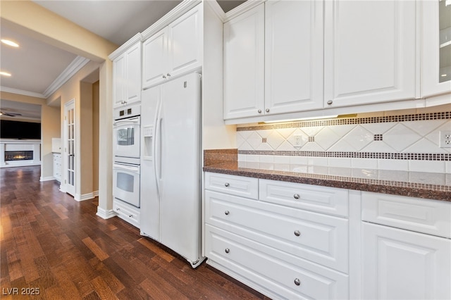 7438 Desertscape Ave, Las Vegas, NV 89178 - kitchen with white appliances, crown molding, white cabinets, tasteful backsplash, and dark stone counters