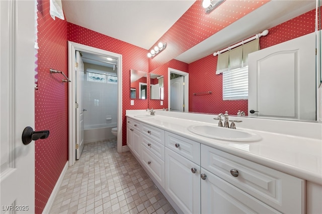 7438 Desertscape Ave, Las Vegas, NV 89178 - bathroom with wallpapered walls, healthy amount of natural light, toilet, double vanity, and baseboards