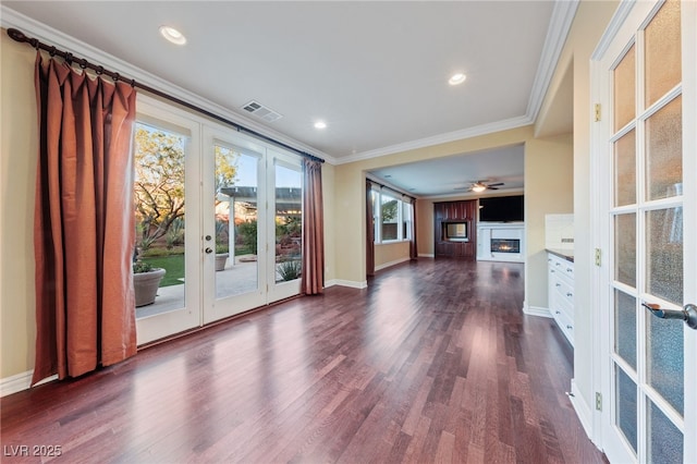 7438 Desertscape Ave, Las Vegas, NV 89178 - unfurnished living room with french doors, a glass covered fireplace, ornamental molding, dark wood-style floors, and baseboards
