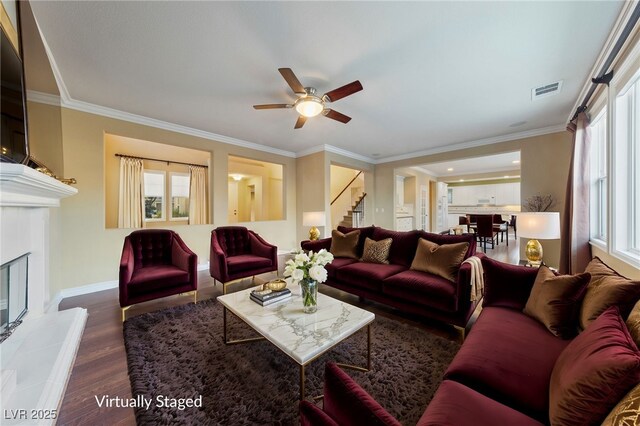 7438 Desertscape Ave, Las Vegas, NV 89178 - living room with stairs, dark wood-style flooring, ceiling fan, crown molding, and baseboards
