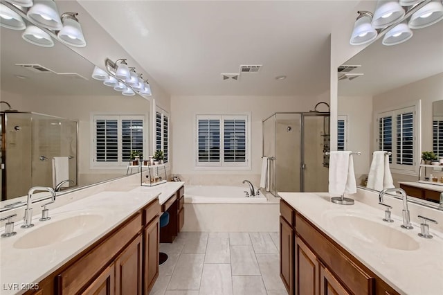 bathroom featuring a stall shower, a garden tub, and two vanities