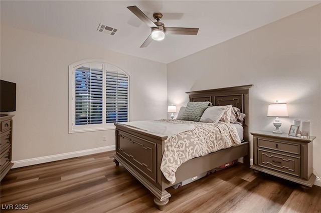 bedroom with dark wood-style floors, baseboards, and a ceiling fan