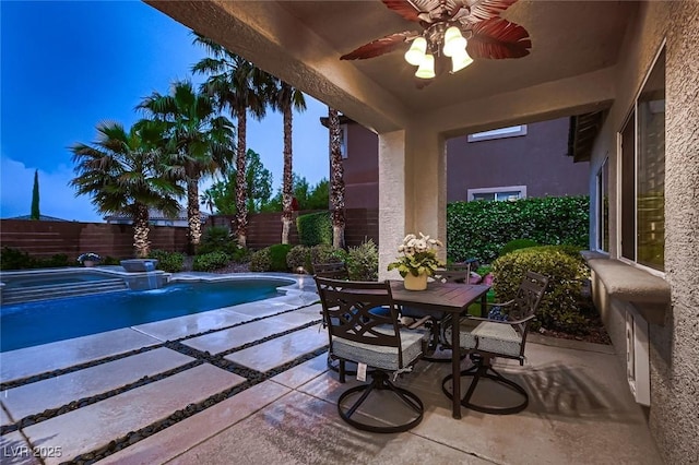view of pool with a fenced backyard, a patio area, outdoor dining area, and ceiling fan