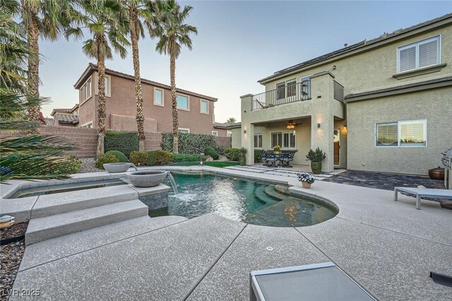 view of swimming pool featuring a patio, fence, and a pool with connected hot tub