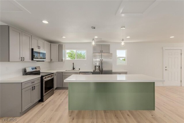 663 D Ave, Boulder City, NV 89005 - kitchen with appliances with stainless steel finishes, gray cabinetry, light wood-style floors, a sink, and a center island