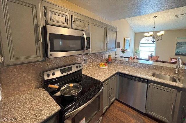 1800 Edmond St Unit 218, Las Vegas, NV 89146 - kitchen with stainless steel appliances, a sink, gray cabinets, tasteful backsplash, and a chandelier