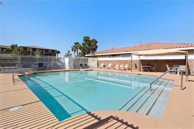 community pool featuring fence and a patio area