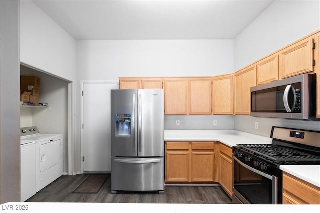 kitchen with appliances with stainless steel finishes, washer and clothes dryer, dark wood-style floors, light countertops, and light brown cabinetry