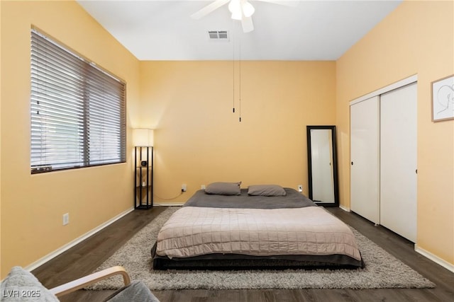 bedroom with wood finished floors, baseboards, a ceiling fan, and a closet