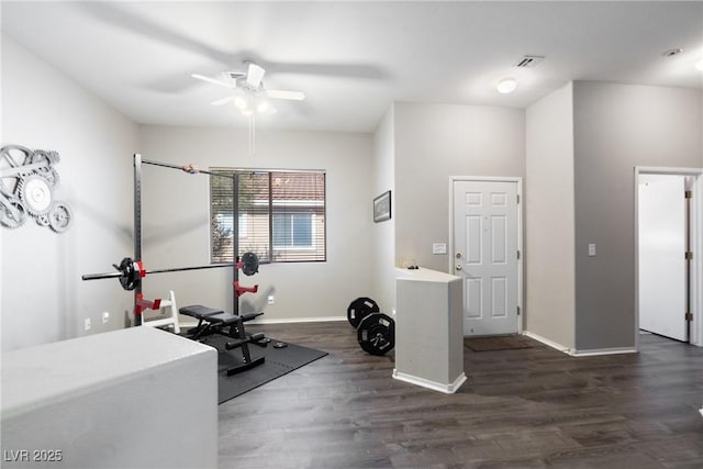 workout area featuring ceiling fan, baseboards, and dark wood-style floors