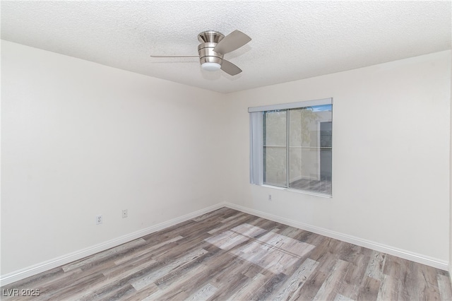 empty room featuring light wood-style floors, a ceiling fan, baseboards, and a textured ceiling