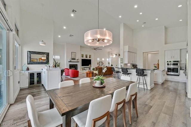 512 Pima Canyon Ct, Las Vegas, NV 89144 - dining area with a high ceiling, beverage cooler, a ceiling fan, light wood-style floors, and recessed lighting