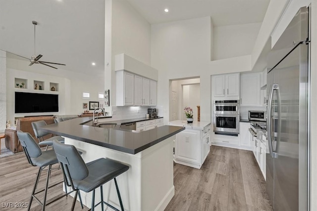 512 Pima Canyon Ct, Las Vegas, NV 89144 - kitchen with appliances with stainless steel finishes, a high ceiling, dark countertops, open floor plan, and a peninsula