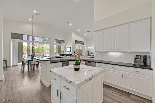 512 Pima Canyon Ct, Las Vegas, NV 89144 - kitchen with high vaulted ceiling, a peninsula, a center island, light wood-style flooring, and white cabinetry