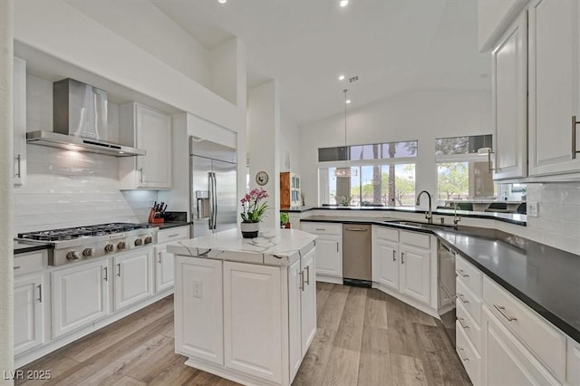 512 Pima Canyon Ct, Las Vegas, NV 89144 - kitchen with wall chimney range hood, stainless steel appliances, backsplash, light wood finished floors, and lofted ceiling
