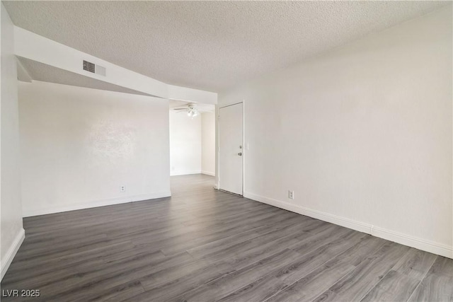 unfurnished room with dark wood-type flooring, a textured ceiling, baseboards, and ceiling fan